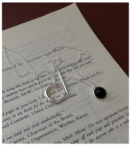 Detail of S925 silver necklace with black agate pendant and OT clasp on a book page
