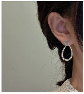 Macro side view of minimalist S925 sterling silver teardrop dangle earrings on model