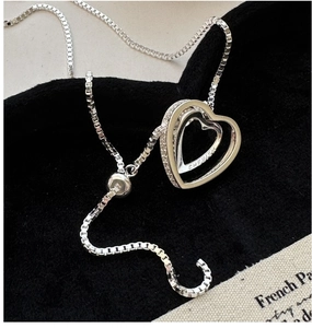 Gros plan du pendentif cœur en argent avec gravure et fermoir coulissant ajustable