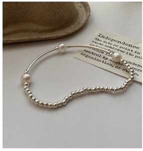 Macro detail of S925 sterling silver beaded bracelet with three lustrous white pearls