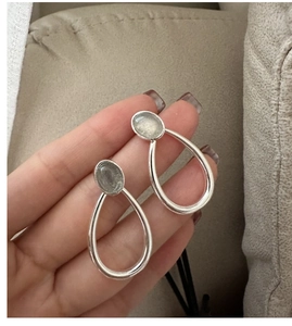 Macro view of S925 sterling silver drop earrings featuring oval moonstone in metal frame