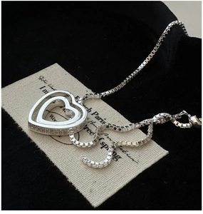 Vue latérale macro du collier coeur en argent S925 avec zircon sur fond de velours noir