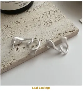 Macro shot of S925 sterling silver leaf earrings with a brushed matte texture finish