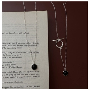 Detail view of S925 silver necklace with black agate pendant and vintage OT clasp on a book