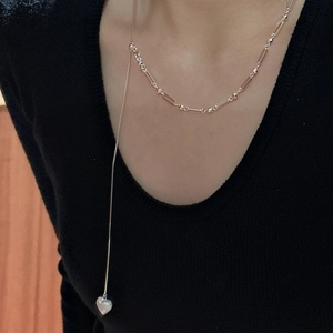 Minimalist S925 sterling silver heart pendant necklace shown on a black sweater background