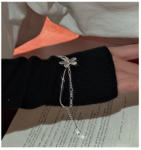 Gros plan d'un bracelet fleur en argent S925 à double épaisseur sur une manche noire
