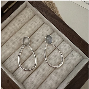 Detailed macro view of S925 sterling silver drop earrings with moonstone on velvet