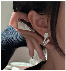 Detailed close-up of matte silver S925 leaf earrings featuring artistic irregular curves