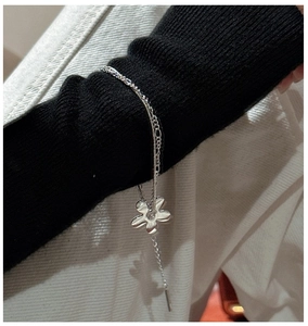 Gros plan du bracelet double couche en argent S925 avec pendentif fleur au poignet