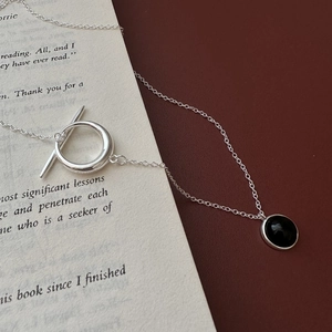S925 silver necklace with black onyx pendant and OT buckle on vintage book pages