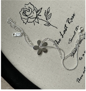 Gros plan d'un bracelet double couche en argent sterling Ag925 avec pendentif petite fleur