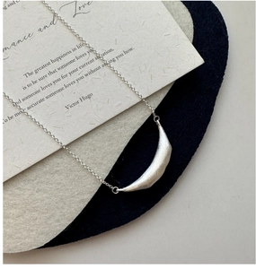 Detail of S925 sterling silver smile necklace with brushed texture on a poetic card