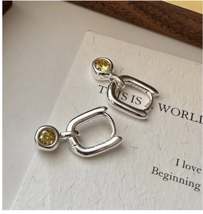Macro view of S925 sterling silver geometric earrings with inlaid yellow square gemstones