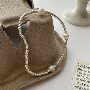 S925 sterling silver beaded bracelet with natural pearls on a minimalist background