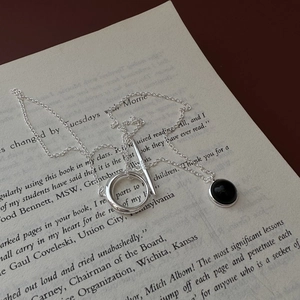 Vintage S925 sterling silver black onyx necklace with OT clasp on an open book