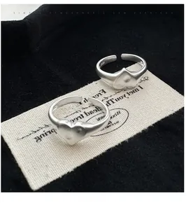 Detail view of matte S925 sterling silver adjustable heart rings on beige textile card
