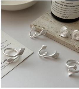 Macro shot of matte S925 sterling silver leaf ring and earrings on a stone base