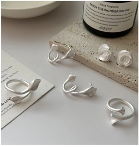 Artistic matte silver jewelry set featuring floral earrings and wrap leaf open rings