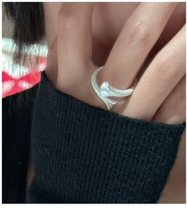 Detail of S925 sterling silver ring with irregular ribbon design worn on finger