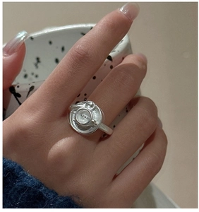Macro shot of minimalist S925 sterling silver ring featuring a unique button-shaped design