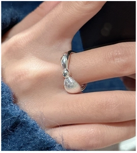 Close-up of S925 sterling silver bow ring with brushed texture on a finger