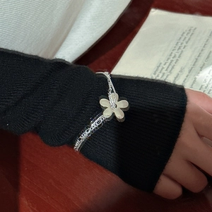 Bracelet double rang en argent S925 avec pendentif fleur blanche porté au poignet