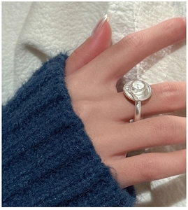 Close-up of a vintage S925 silver ring with a textured button design on finger