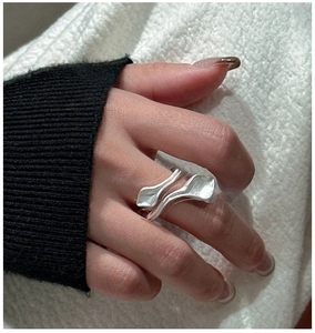 Macro detail of leaf-inspired silver ring with organic curves and matte finish texture