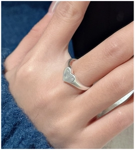 Close-up of a matte S925 sterling silver heart signet ring worn on a finger