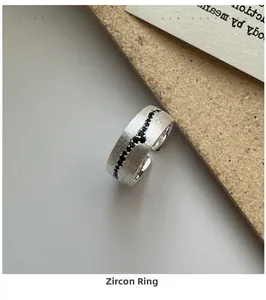 Detailed close-up of brushed S925 sterling silver ring with wave-set black zircon stones