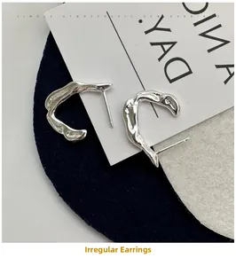 Close-up of irregular S925 sterling silver hook earrings on minimalist felt props