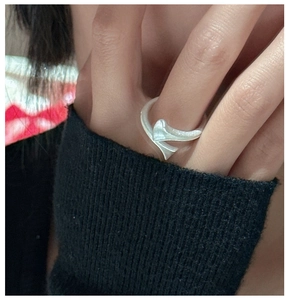 Macro view of a minimalist S925 sterling silver twist ring worn on the index finger