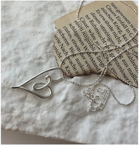 Detail of S925 sterling silver heart pendant with Ag925 hallmark on a link chain