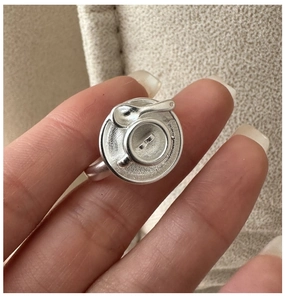 Macro detail of S925 silver coffee cup ring with miniature spoon and matte texture