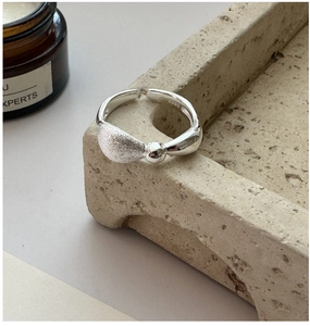 Close-up of S925 sterling silver ring featuring brushed texture and asymmetric opening