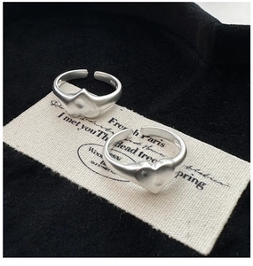 Detailed macro view of S925 sterling silver heart rings with matte finish and logo