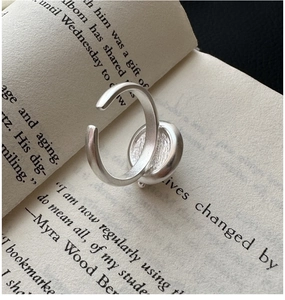 Detail of matte S925 sterling silver coffee cup ring placed on a vintage book page