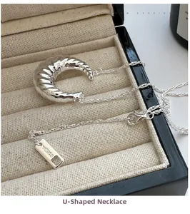 Dettaglio del ciondolo a croissant in argento S925 con texture a spirale definita