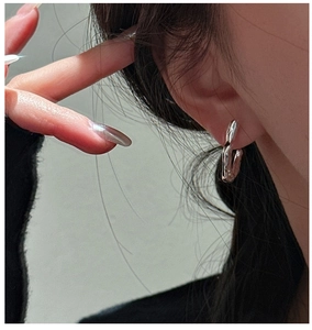 Detailed view of S925 sterling silver hook earrings with liquid metal texture on a model