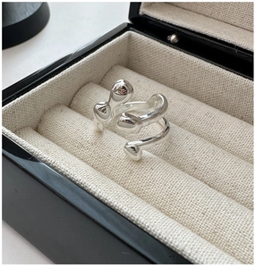 Detailed close-up of a silver fluid-style wrap ring with smooth spherical liquid-like ends