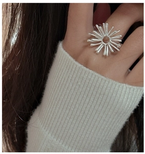 Detailed close-up of a S925 sterling silver starburst fireworks ring on a finger