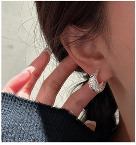 Macro side view of textured S925 sterling silver hoop earring on model showing lava texture