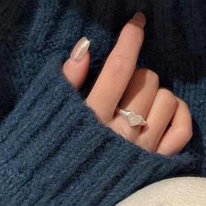 Minimalist S925 sterling silver heart ring with matte finish worn on hand over cozy sweater