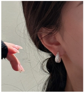 Detail of S925 sterling silver earring with textured hammer finish on female model