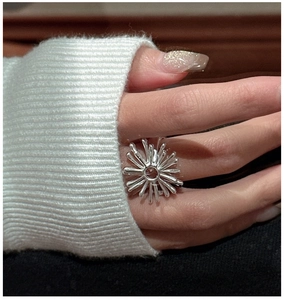 Close-up of S925 silver vintage firework ring on hand with a white knit sweater cuff