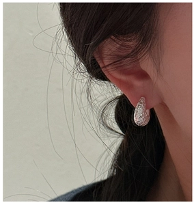 Close-up of S925 sterling silver earring with lava texture and minimalist metallic finish