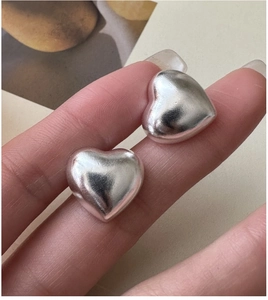 Detailed view of S925 sterling silver hollow heart earrings with polished matte texture