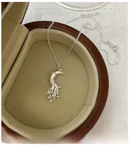 Detail of S925 sterling silver moon and star tassel necklace in a wooden jewelry box