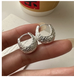 Macro shot of S925 sterling silver hoop earrings with irregular hammered texture