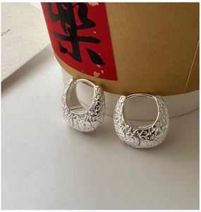 Close-up of S925 sterling silver hoop earrings with textured molten metal surface